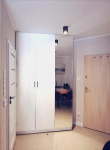 a sliding glass door leading into a room with a table at Apartament Sand&Blue z basenem in Sztutowo +6 photos