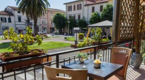 einen Balkon mit einem Tisch, Stühlen und einer Straße in der Unterkunft Park Hotel in Montecatini Terme