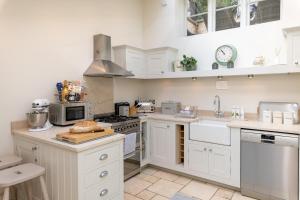 a kitchen with white cabinets and white appliances at Seventeen The Town House Bath in Bath