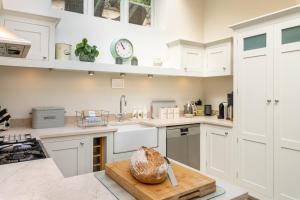 a kitchen with white cabinets and a counter top at Seventeen The Town House Bath in Bath