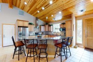a kitchen with a large island with bar stools at Murray Lake Retreat in Bass Lake +5 photos
