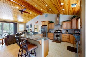 eine große Küche mit Holzdecken und einem Deckenventilator in der Unterkunft Murray Lake Retreat in Bass Lake