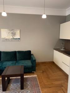 a living room with a green couch and a table at Cathedral Apartments in Kaunas
