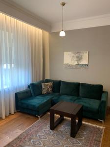 a living room with a green couch and a coffee table at Cathedral Apartments in Kaunas