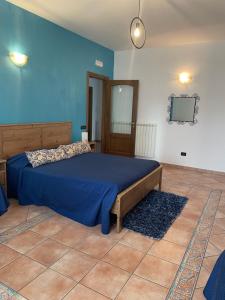 a bed in a room with a blue wall at Colle Uliveto in Vico Equense