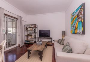 a living room with a white couch and a table at Cozy 3 bedroom apartment in front of the subway in Lisbon