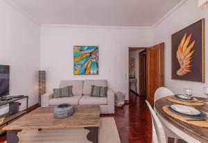 ein Wohnzimmer mit einem Sofa und einem Tisch in der Unterkunft Cozy 3 bedroom apartment in front of the subway in Lissabon
