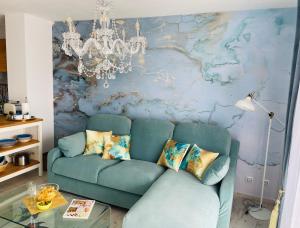 a living room with a blue couch and a wall at Blue House Mallorca in Ses Salines