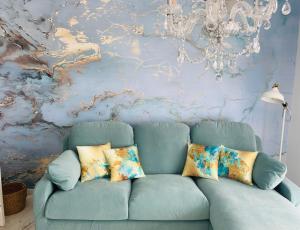a blue couch in a living room with a chandelier at Blue House Mallorca in Ses Salines