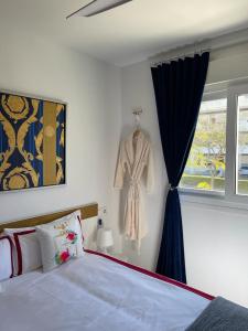 a bedroom with a bed and a dress hanging in a window at Casa Beau Murcia, Condado de Alhama in El Romero