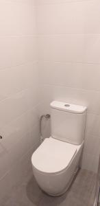 a bathroom with a white toilet in a room at APARTAMENTOS DON MANUEL D in Cee