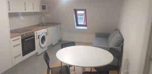 a kitchen with a table and a table and chairs at APARTAMENTOS DON MANUEL D in Cee