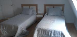 two beds sitting next to each other in a room at APARTAMENTOS DON MANUEL D in Cee