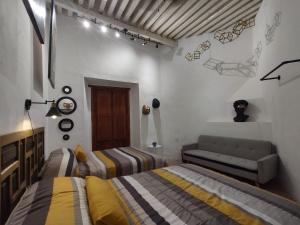 ein Schlafzimmer mit zwei Betten und einem Sofa darin in der Unterkunft Terrazas de la Alameda - Panoramic Aparthotel by Lunian in Guanajuato