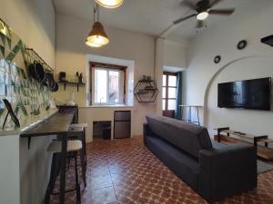 ein Wohnzimmer mit einem Sofa und einem TV in der Unterkunft Terrazas de la Alameda - Panoramic Aparthotel by Lunian in Guanajuato