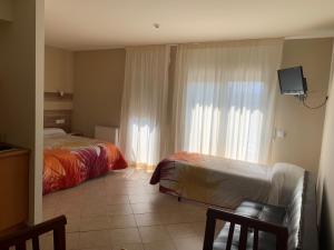 a hotel room with two beds and a window at RAQUEL'S - Habitacions i Apartaments turístics - in Sant Pere Pescador