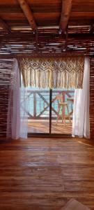a window with a curtain in a room with a table at Hotel Calamari Baru in Playa Blanca +55 photos