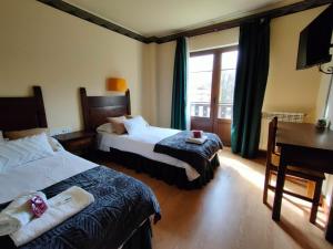 Un pat sau paturi într-o cameră la Hotel Cumbres de Valdeón