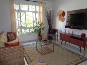 a living room with a couch and a tv at Residência Colibri apto 07 in Porto Seguro