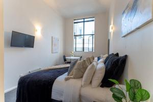 a bedroom with a bed with a couch and a tv at Bright CBD Studio -Near SkyTower - WiFi - Cityscape in Auckland