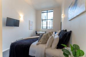1 dormitorio con 1 cama con sofá y TV en Bright CBD Studio -Near SkyTower - WiFi - Cityscape, en Auckland
