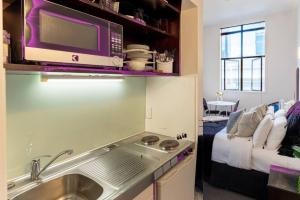 una cocina con fregadero y microondas en Bright CBD Studio -Near SkyTower - WiFi - Cityscape, en Auckland 20 fotos más
