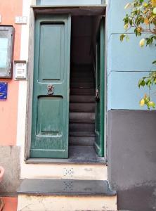 eine grüne Tür und Treppe in einem Gebäude in der Unterkunft Sensazioni liguri - By Ligooria in Pietra Ligure