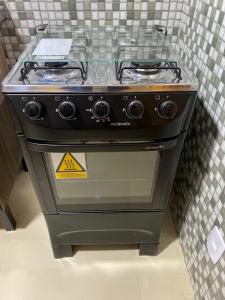 a stove top oven with a warning sign on it at Chalés Bem-me-quer Itaipava in Itaipava
