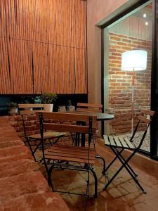 ein Zimmer mit einem Tisch, Stühlen und einer Ziegelwand in der Unterkunft Mina 32 - Coyoacan in Mexiko-Stadt