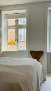 a bedroom with a bed and a window with an umbrella at ApartmentInCopenhagen Apartment 1484 in Copenhagen