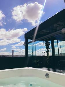 a bath tub with a view of the sky at Cobertura Hidro BH Espaço gourmet e hidromassagem in Pampulha