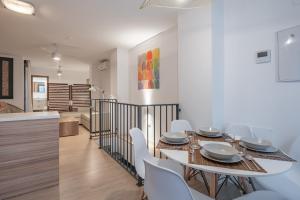 a dining room with a table and white chairs at Suite Homes Parras duplex in Málaga