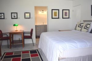 um quarto com uma cama, uma mesa e cadeiras em West Racquet Club Art Room em Palm Springs