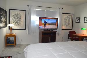 Schlafzimmer mit einem Bett und einem Flachbild-TV in der Unterkunft West Racquet Club Art Room in Palm Springs