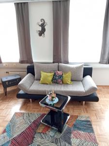 uma sala de estar com um sofá e uma mesa de centro em City Apartmentstudio mit Tiefgarage free parking em Graz