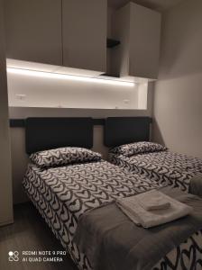 a bedroom with two beds with a light above them at BLU apartment in Civitanova Marche