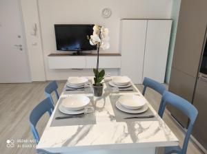 a dining room table with plates and a flower on it at BLU apartment in Civitanova Marche