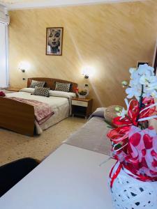 sypialnia z 2 łóżkami i wazonem z kwiatami w obiekcie Bed And Breakfast Torretta w mieście Controguerra