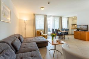 a living room with a couch and a table at Haus Strandburg - hinter Düne und Meer in Binz