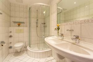 a bathroom with a sink and a shower and a toilet at Haus Strandburg - hinter Düne und Meer in Binz +97 photos