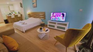 Sala de estar con cama y TV en STAY Eden Beach Studio en Limassol