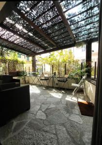 une terrasse avec une pergola, une table et des chaises dans l'établissement Locanda Sapori, à Sanremo