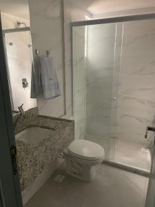 a white bathroom with a toilet and a shower at Hotel do Mar Tambaú in João Pessoa