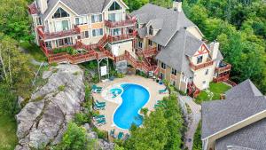 uma vista aérea de uma grande casa com piscina em Hauts-bois Ski Inout 2brs Wpool Access 193-1 em Mont-Tremblant