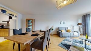 a dining table and chairs in a living room at Le Nid Cosy + 1 Garage in Colmar +4 photos