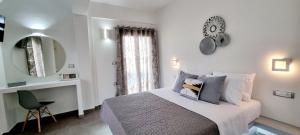 een slaapkamer met een bed met een klok aan de muur bij Ether in Perivolos