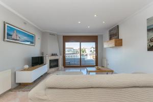 Schlafzimmer mit einem Bett, einem TV und einem Kamin in der Unterkunft Casa con vista al canal in Roses