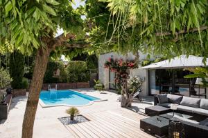 une cour avec une piscine et un arbre dans l'établissement Le Logis de La Brumanderie - Saintes, à Fontcouverte