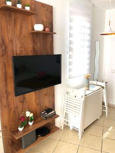 ein Wohnzimmer mit einem Flachbild-TV an einer Holzwand in der Unterkunft Apartamento Te Miti in Puerto del Carmen