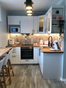 cocina con armarios blancos y encimera de madera en Niine apartment 12, en Haapsalu